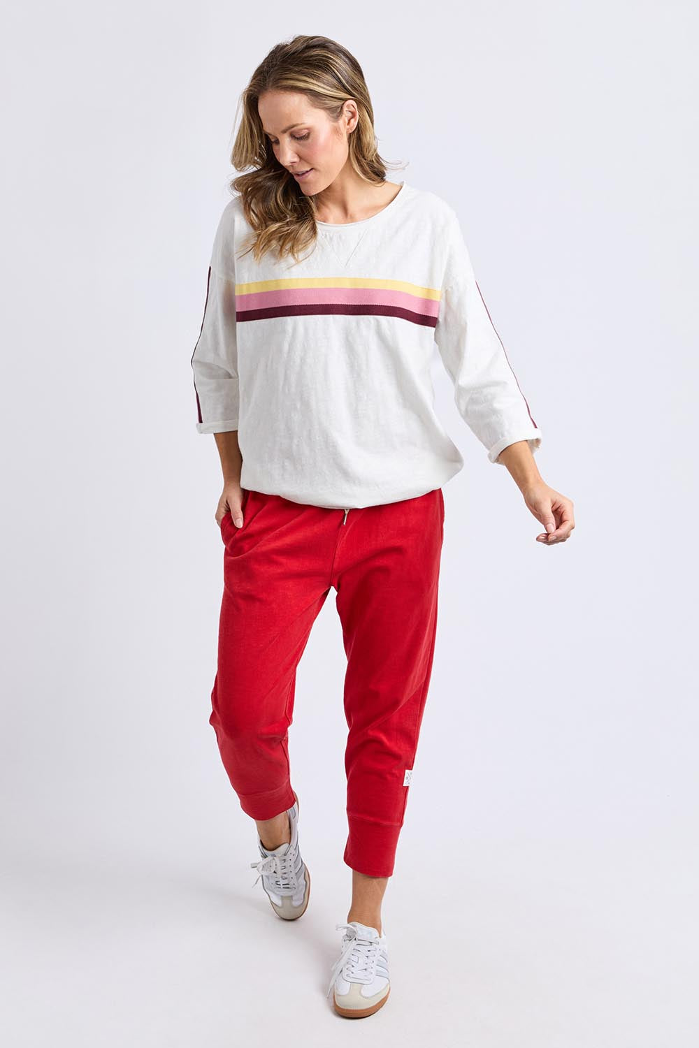 A model wearing the Fundamental Brunch Cotton Pant in colour Cranberry (Red), from the front, showing the whole outfit