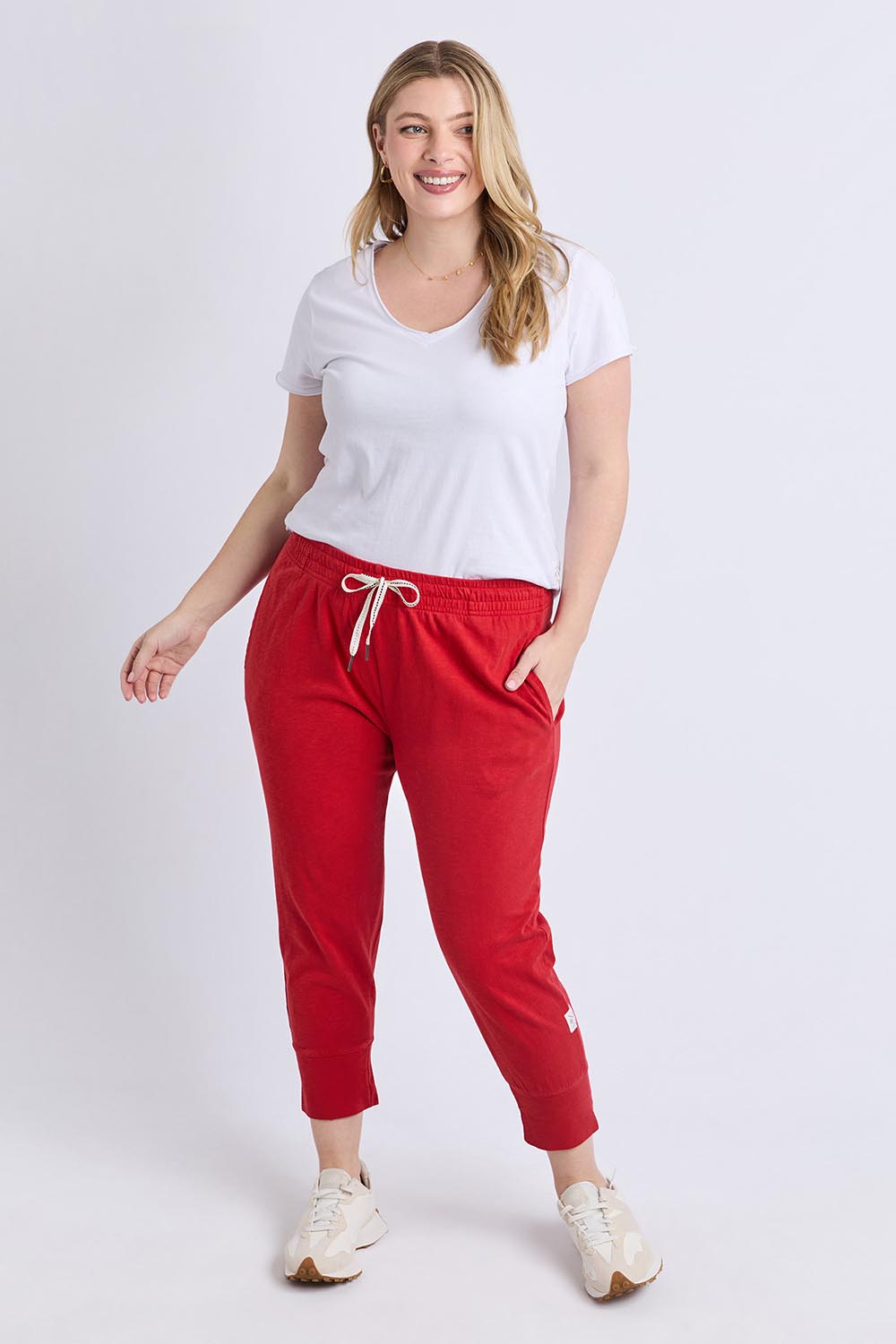 A model wearing the Fundamental Brunch Cotton Pant in colour Cranberry (Red), from the front, showing the whole outfit