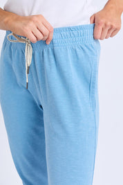 A model wearing the Fundamental Brunch Cotton Pant in colour Duskblue (Blue), from the front, cropped image