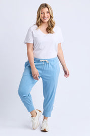 A model wearing the Fundamental Brunch Cotton Pant in colour Duskblue (Blue), from the front, showing the whole outfit