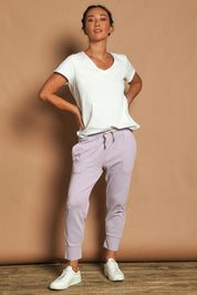 Model Katie wearing size 10 of the Fundamental Brunch Cotton Pant in colour Dustylilac (Purple), from the front, showing the whole outfit