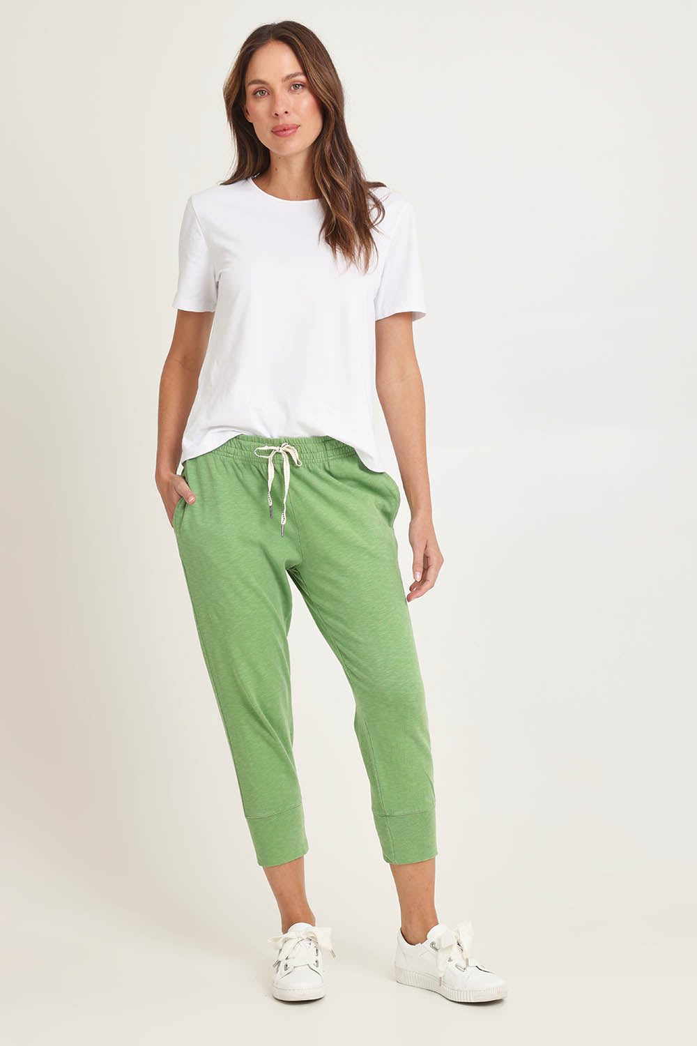 Model Madeline wearing size 10 of the Fundamental Brunch Cotton Pant in colour Forest (Green), from the front, showing the whole outfit