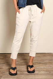 Model Pamelar wearing size 10 of the Fundamental Brunch Cotton Pant - Linen in colour Linen, in a cropped view