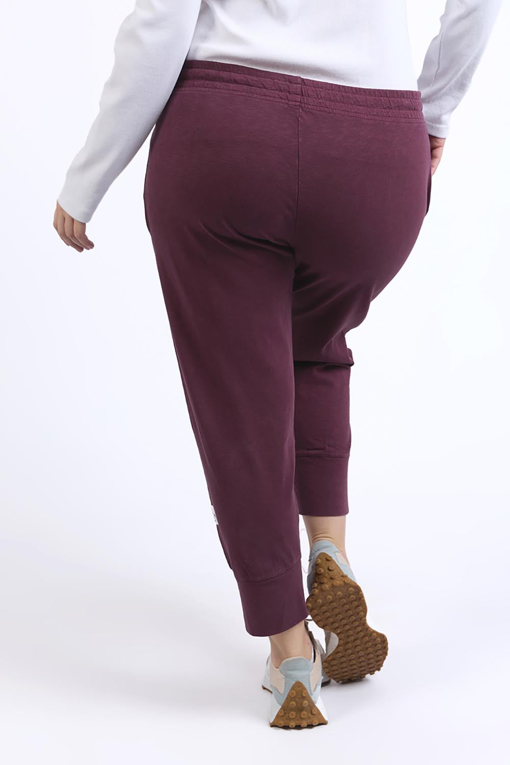 A model wearing the Fundamental Brunch Cotton Pant in colour Merlot (Red), from the back
