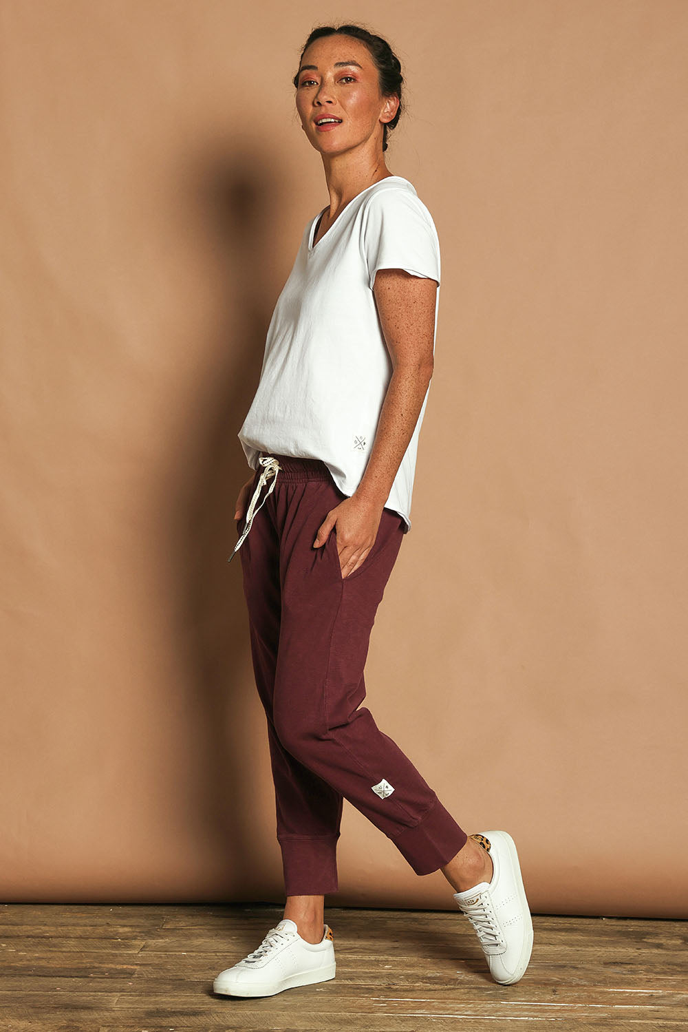 Model Katie wearing size 10 of the Fundamental Brunch Cotton Pant in colour Merlot (Red), from the front, showing the whole outfit