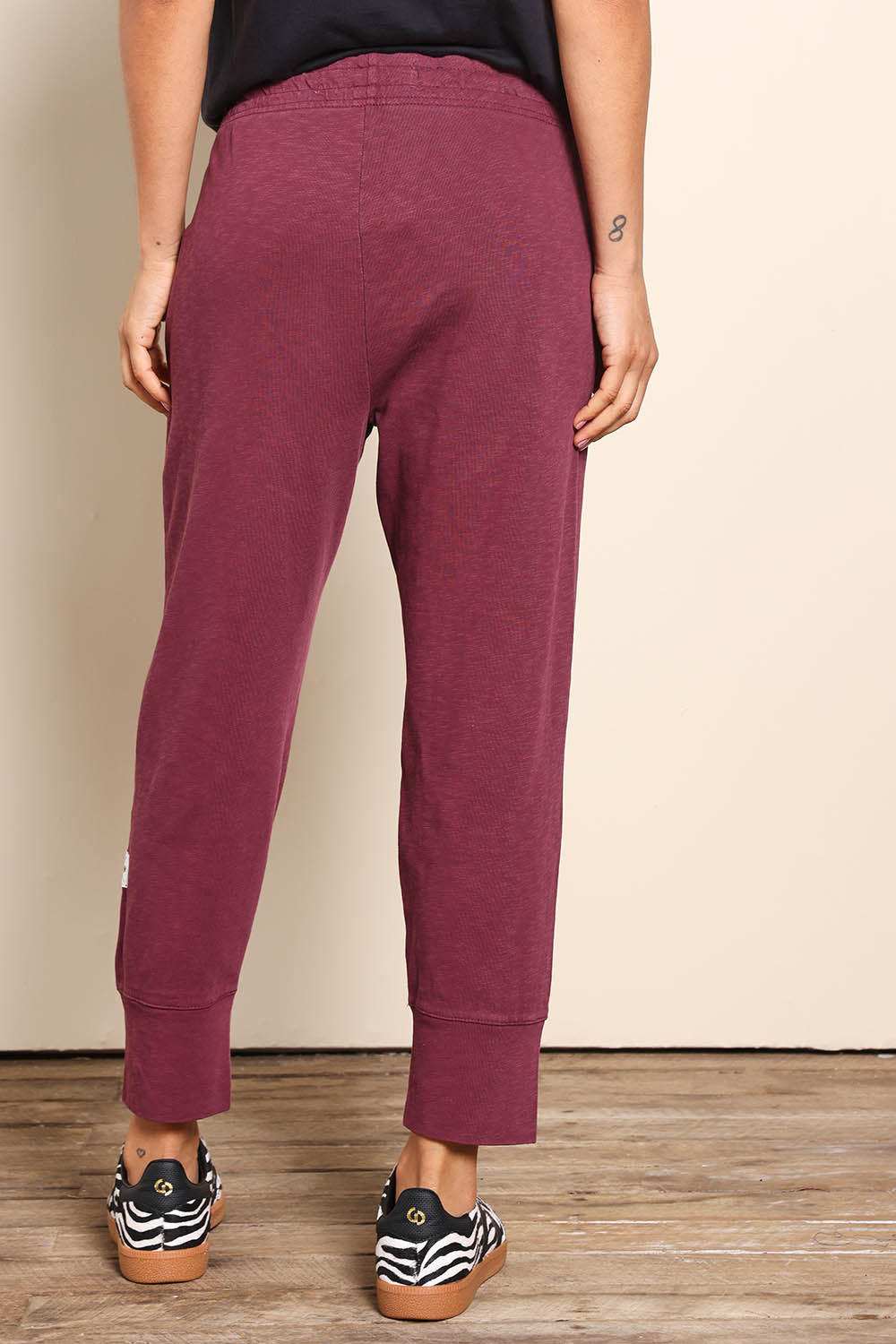 Model Pamelar wearing size 10 of the Fundamental Brunch Cotton Pant - Merlot in colour Merlot, from the back