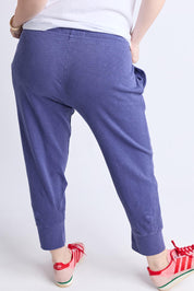 A model wearing the Fundamental Brunch Cotton Pant in colour Vintagebl (Blue), from the back