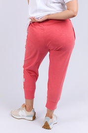 A model wearing the Fundamental Brunch Cotton Pant in colour Watermelon (Red), from the back