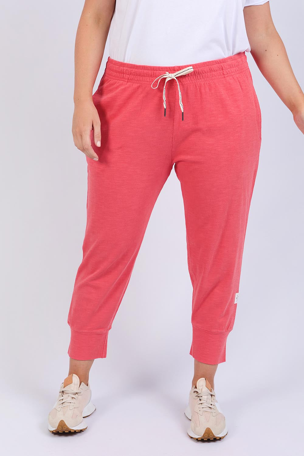 A model wearing the Fundamental Brunch Cotton Pant in colour Watermelon (Red), from the front, cropped image