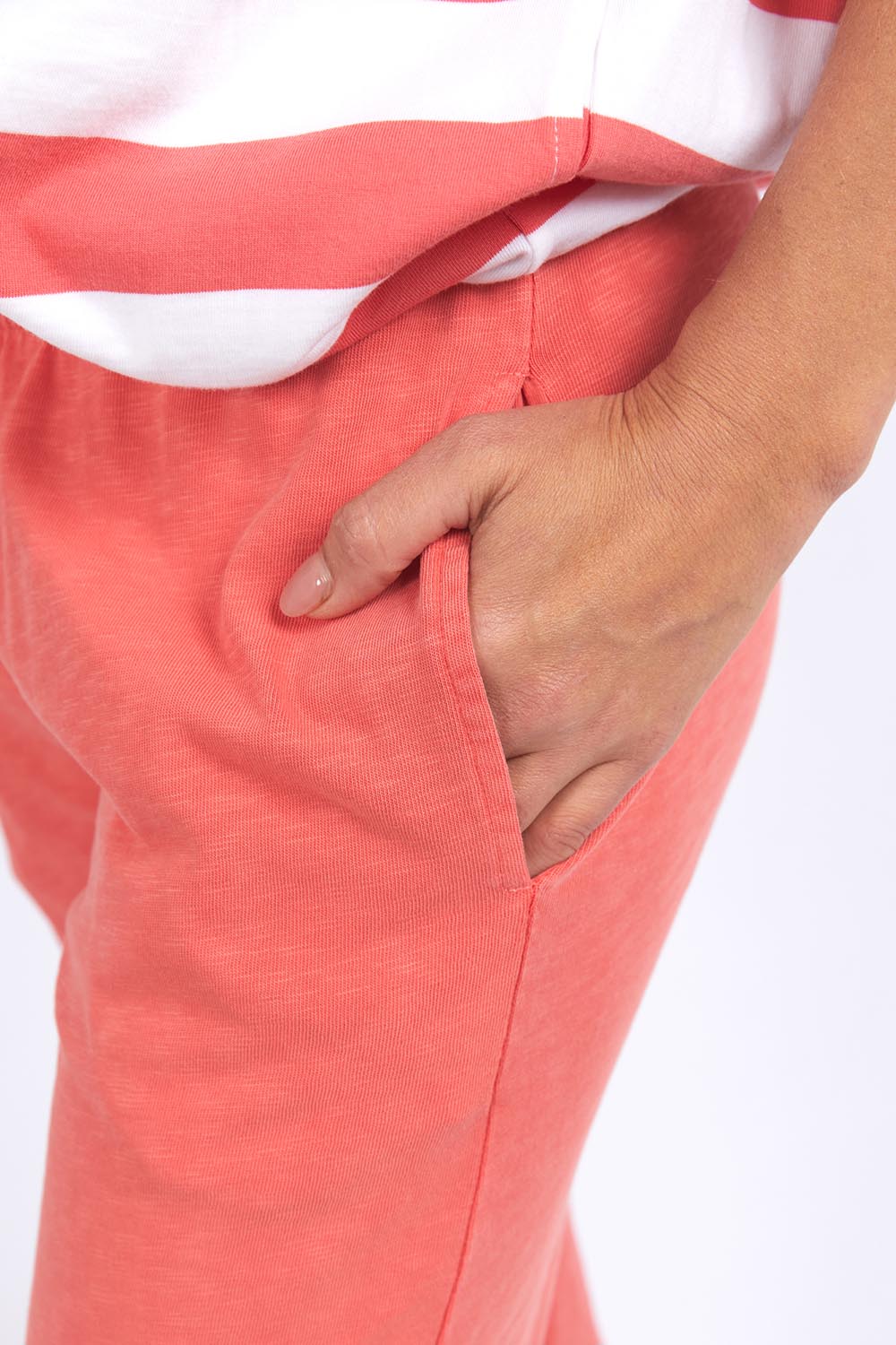 A model wearing the Fundamental Brunch Cotton Pant in colour Watermelon (Red), from the front, cropped image