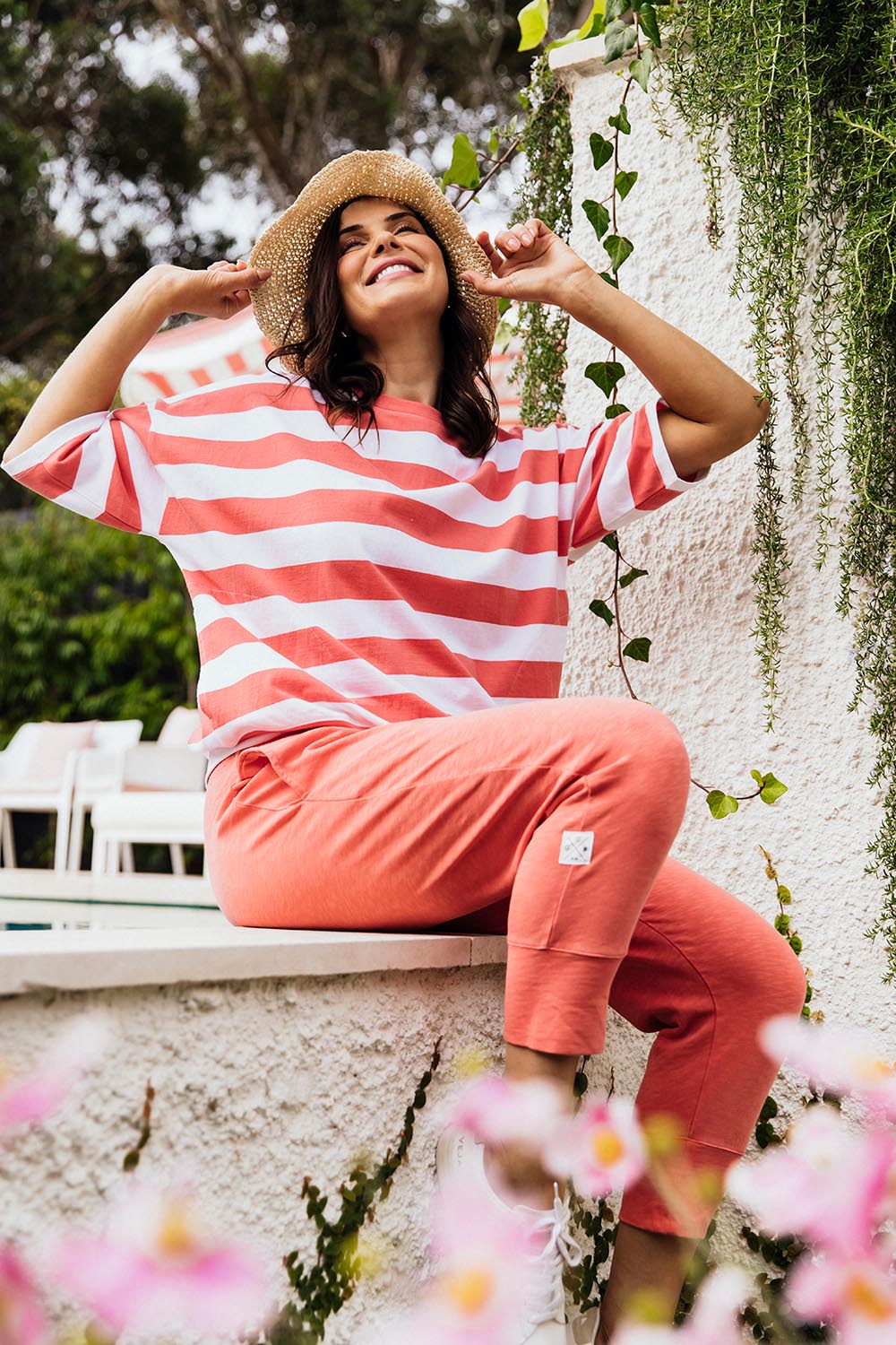 A model wearing the Fundamental Brunch Cotton Pant in colour Watermelon (Red), from the front, showing the whole outfit