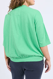 A model wearing the Fundamental Mazie Cotton Sweat Top in colour Springgree (Green), from the back