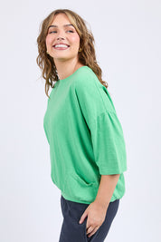 A model wearing the Fundamental Mazie Cotton Sweat Top in colour Springgree (Green), from the front, cropped image