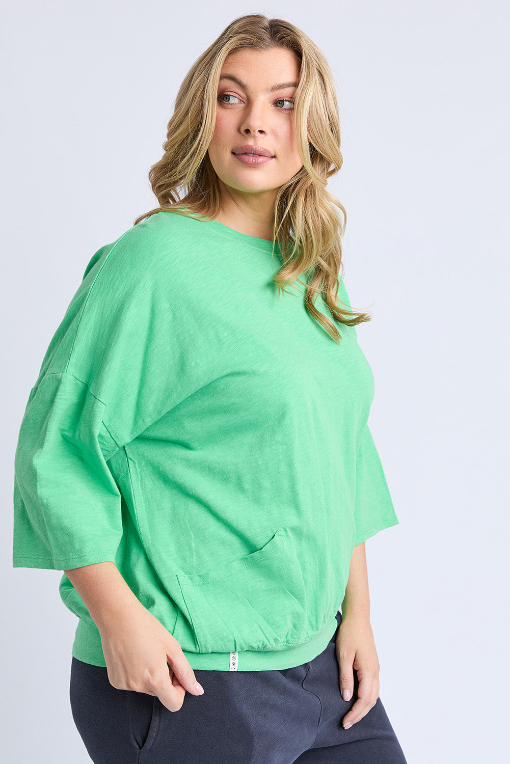 A model wearing the Fundamental Mazie Cotton Sweat Top in colour Springgree (Green), from the front, cropped image