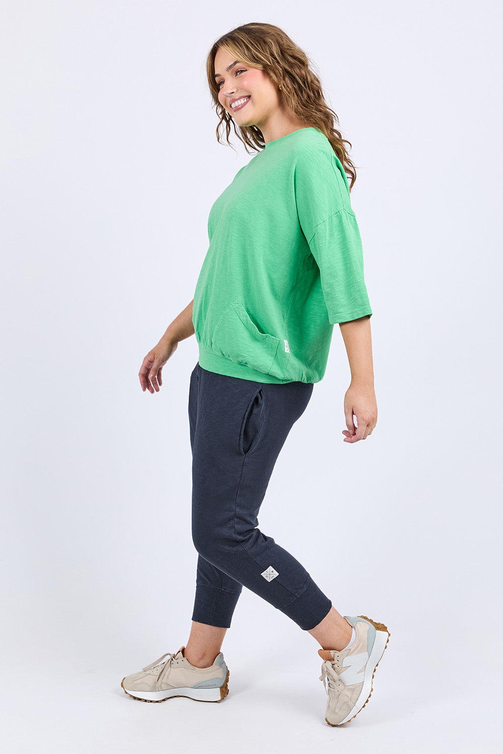 A model wearing the Fundamental Mazie Cotton Sweat Top in colour Springgree (Green), from the front, showing the whole outfit