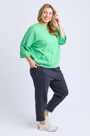 A model wearing the Fundamental Mazie Cotton Sweat Top in colour Springgree (Green), from the front, showing the whole outfit