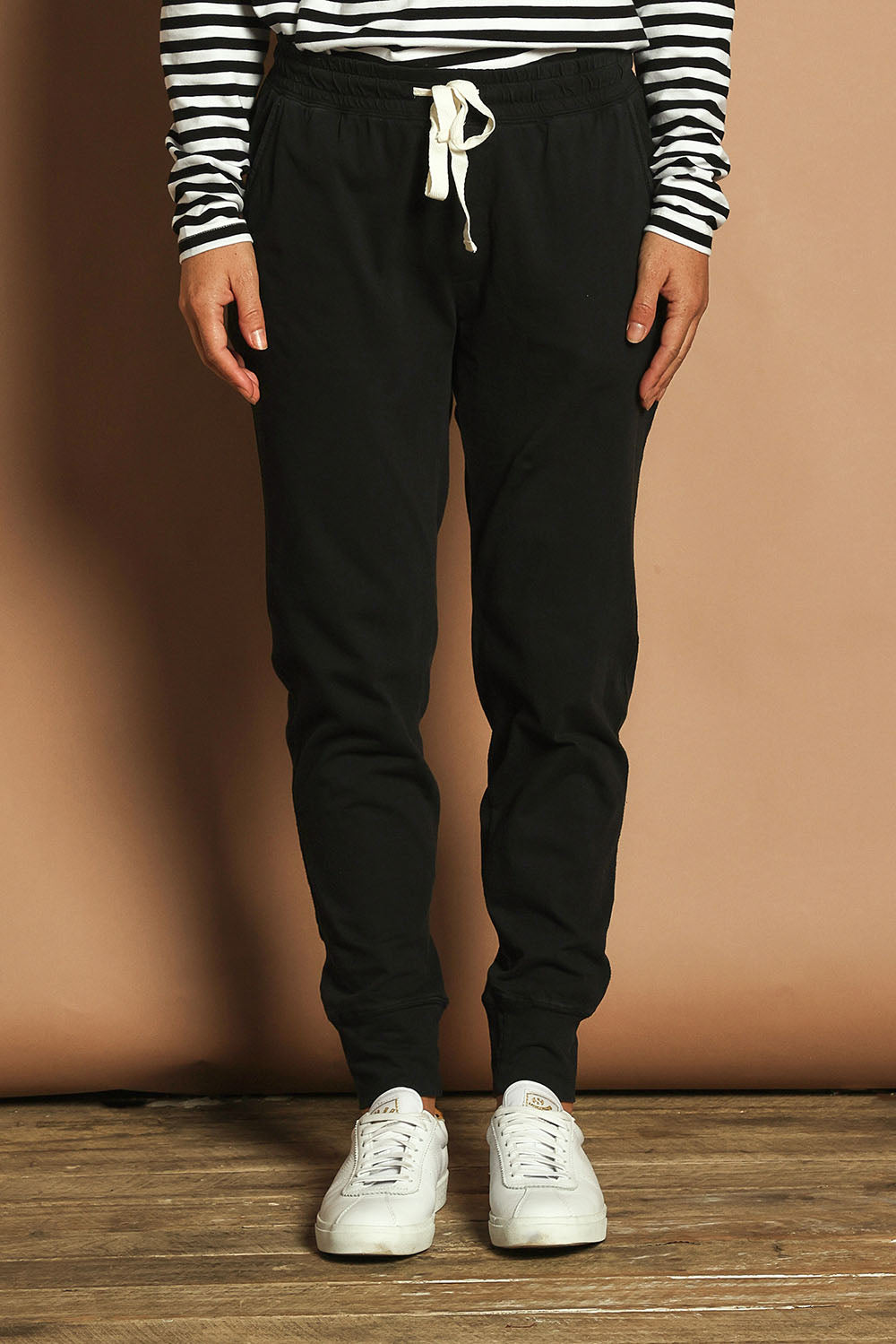 Model Katie wearing size 10 of the Fundamental Wash Out Pant in colour Black (Black), from the front, cropped image