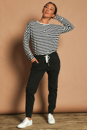 Model Katie wearing size 10 of the Fundamental Wash Out Pant in colour Black (Black), from the front, showing the whole outfit