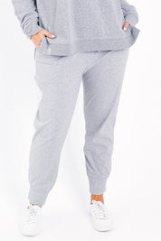 Model Jessica wearing size 14 of the Fundamental Wash Out Pant in colour Greymarle (Grey), from the front, cropped image