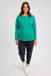 A model wearing the Fundamental Rib Long Sleeve Tee in colour Goodgreen (Green), from the front, showing the whole outfit
