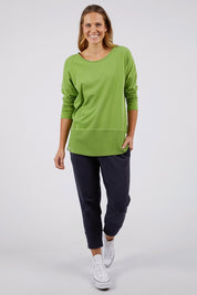 A model wearing the Fundamental Rib Long Sleeve Tee in colour Junglegre (Green), from the front, showing the whole outfit