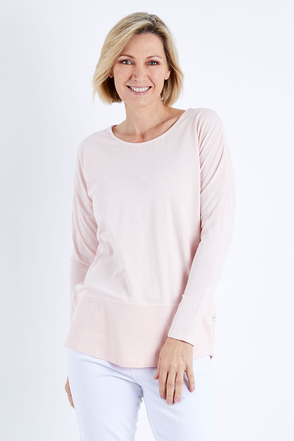 Model Veronica wearing size 10 of the Fundamental Rib Long Sleeve Tee in colour Palepink (Pink), from the front, cropped image