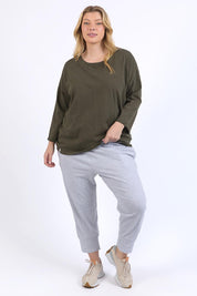 A model wearing the Fundamental Annie 3/4 Sleeve Tee in colour Basil (Green), from the front, showing the whole outfit