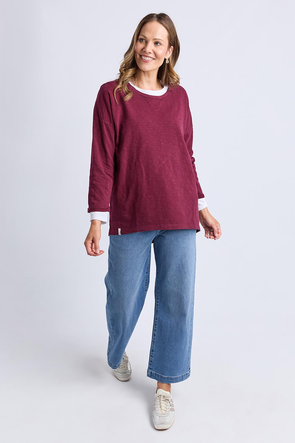 A model wearing the Fundamental Annie 3/4 Sleeve Tee in colour Plum (Purple), from the front, showing the whole outfit