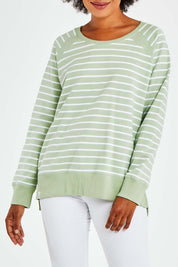 Model Olivia wearing size 10 of the Fundamental Sydney Crew in colour Greenstrip (Green), from the front, cropped image