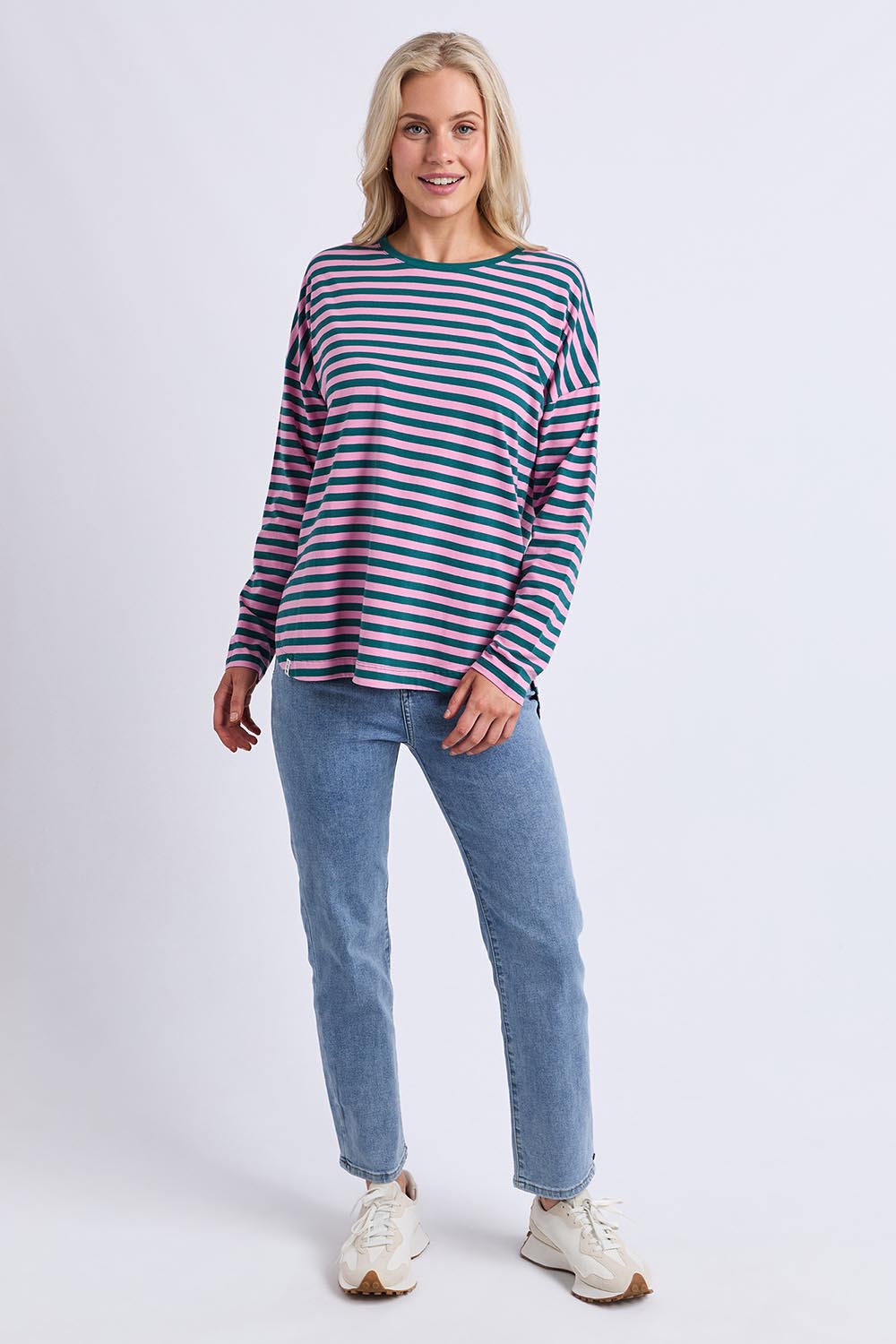 A model wearing the Fundamental Lauren Stripe LS Tee in colour Tealpink (Blue), from the front, showing the whole outfit