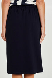 Model Madeline wearing size 10 of the Fundamental Rib Midi Skirt in colour Navy (Blue), from the back