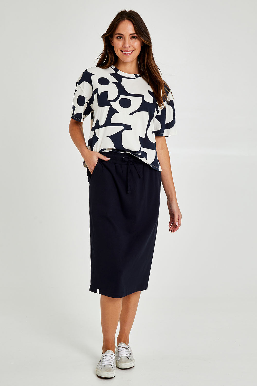 Model Madeline wearing size 10 of the Fundamental Rib Midi Skirt in colour Navy (Blue), from the front, showing the whole outfit