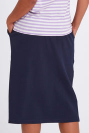 Model Olivia wearing size 10 of the Fundamental Rib Midi Skirt in colour Navy (Blue), from the back