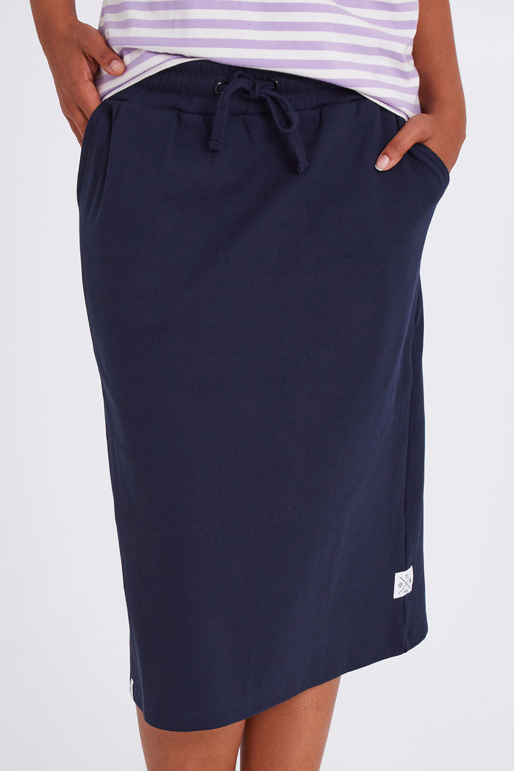 Model Olivia wearing size 10 of the Fundamental Rib Midi Skirt in colour Navy (Blue), from the front, cropped image