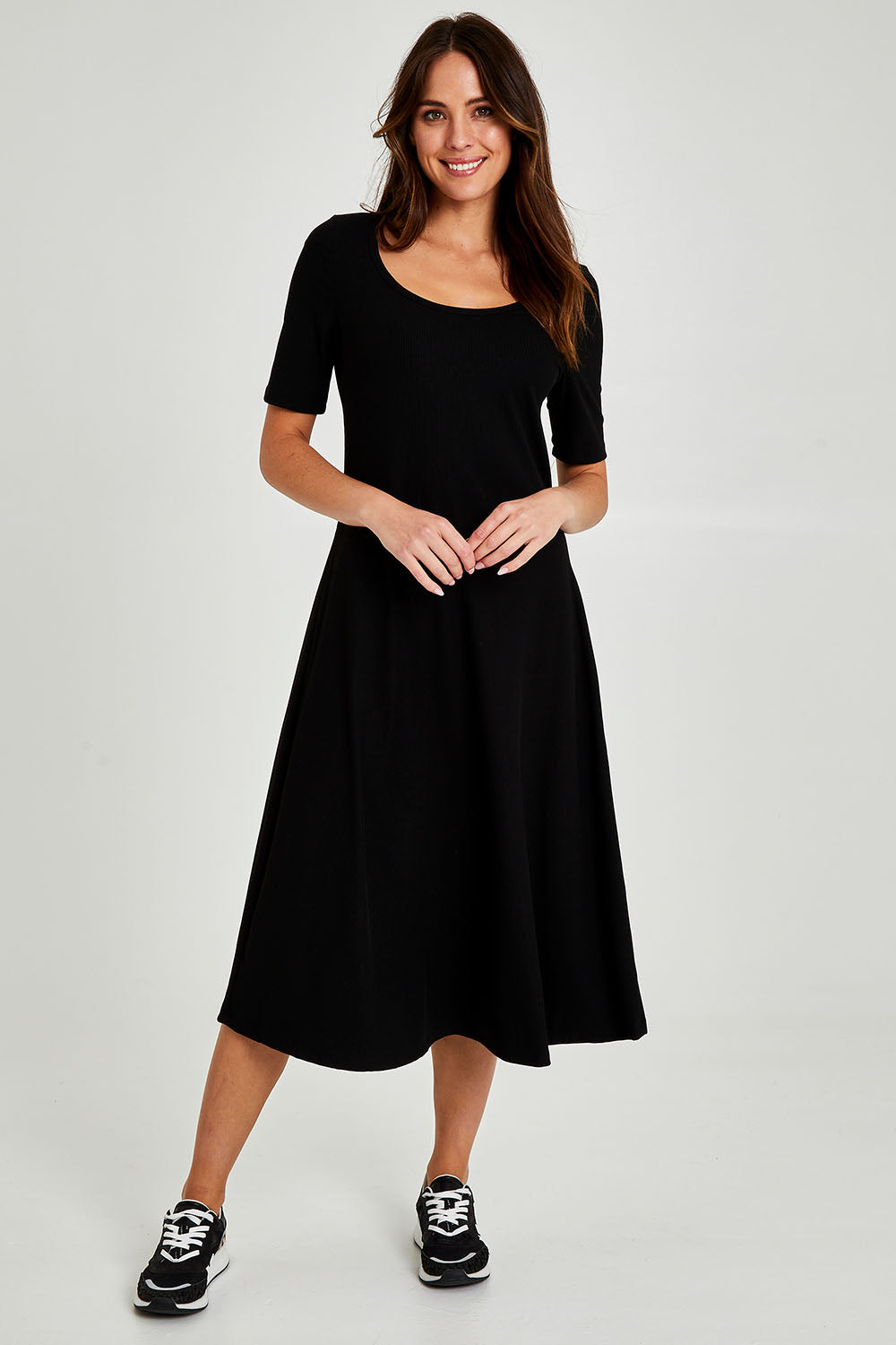 Model Madeline wearing size 10 of the Fundamental Marguerite Dress in colour Black (Black), from the front, showing the whole outfit