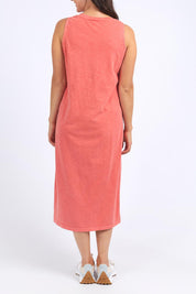 A model wearing the Fundamental Elysian Cotton Dress in colour Watermelon (Red), from the back