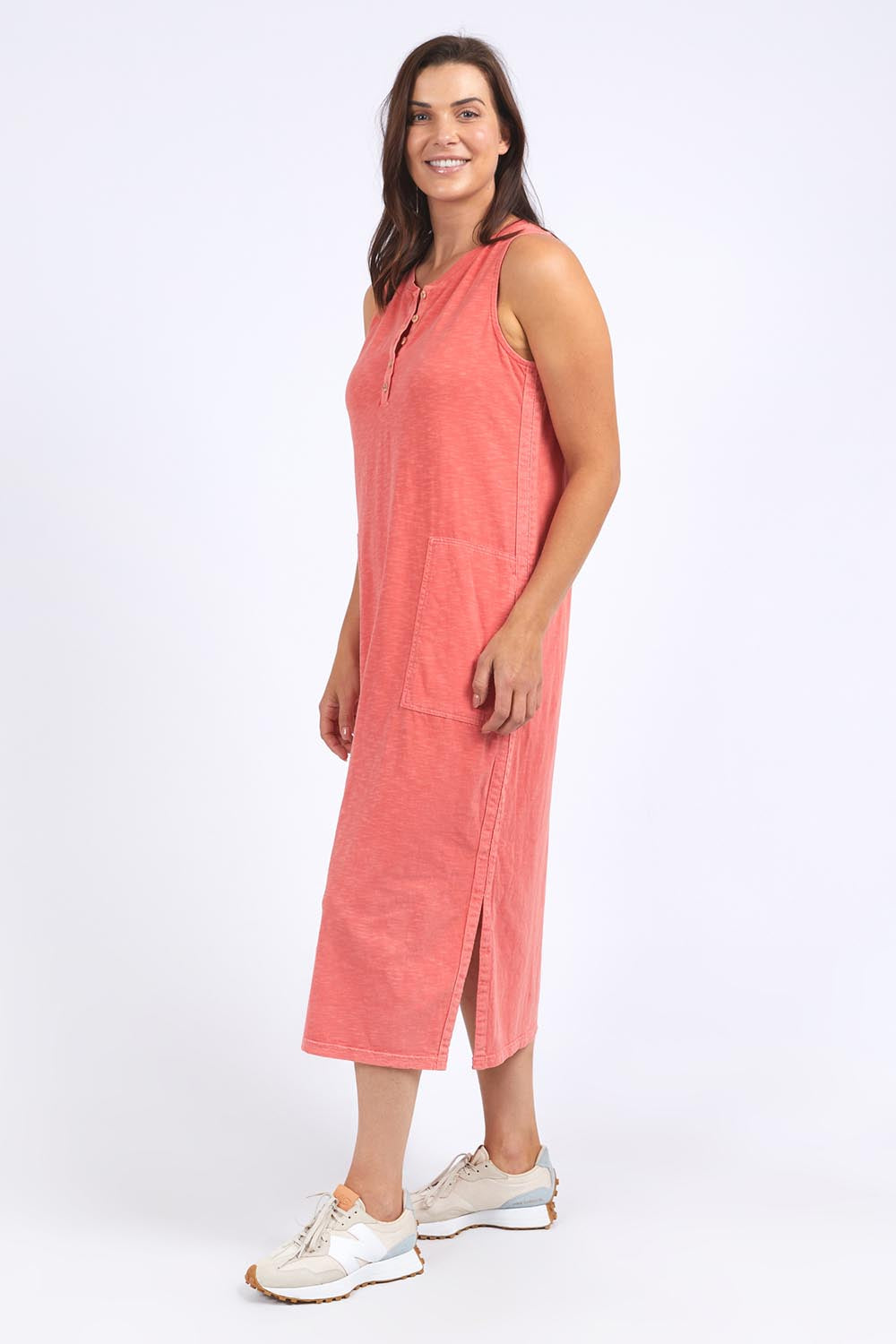 A model wearing the Fundamental Elysian Cotton Dress in colour Watermelon (Red), from the front, showing the whole outfit