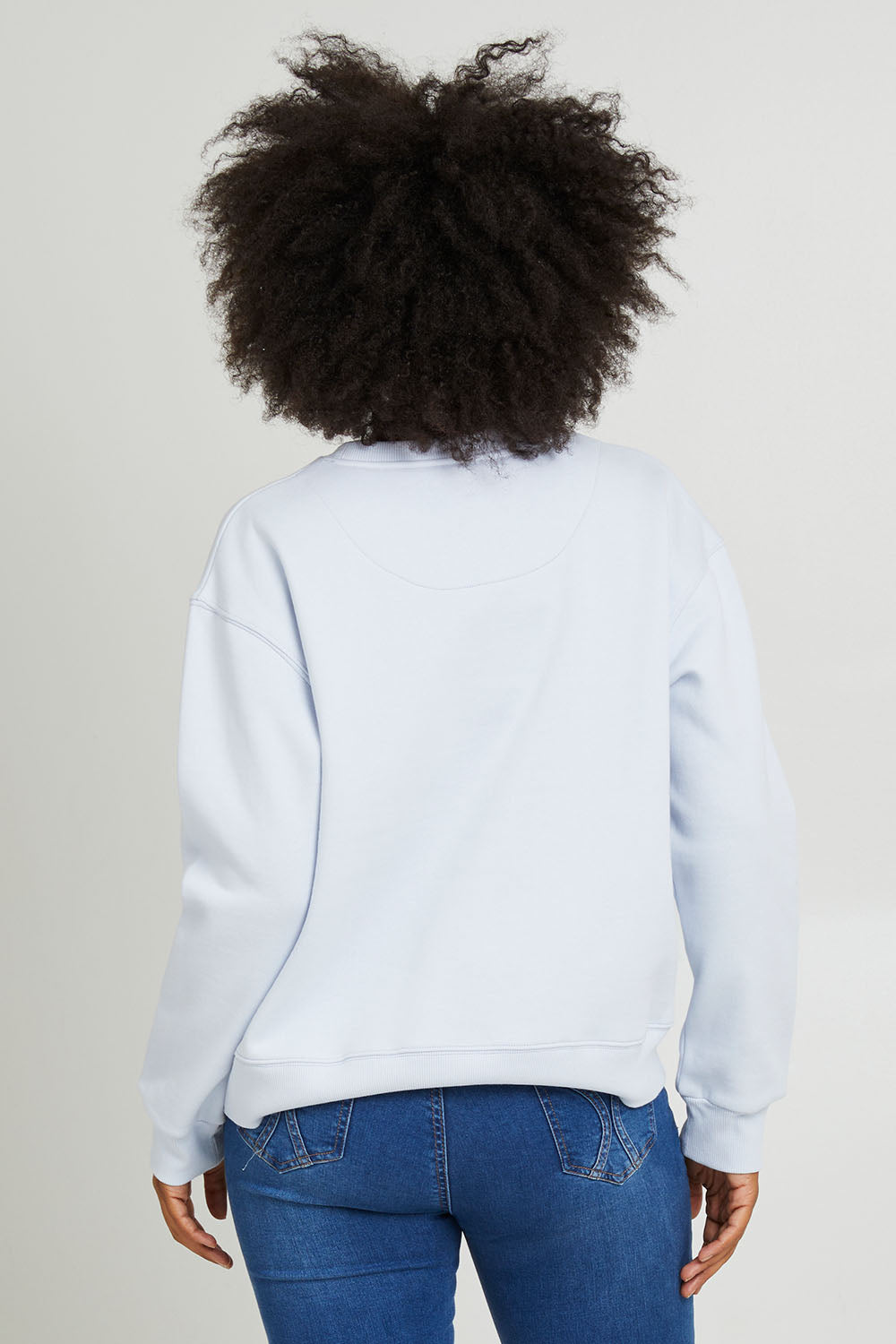 Model Olivia wearing size 10 of the Fundamental Shelly Fleece Crew in colour Lightblue (Blue), from the back