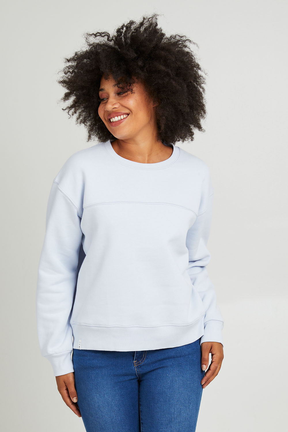 Model Olivia wearing size 10 of the Fundamental Shelly Fleece Crew in colour Lightblue (Blue), from the front, cropped image