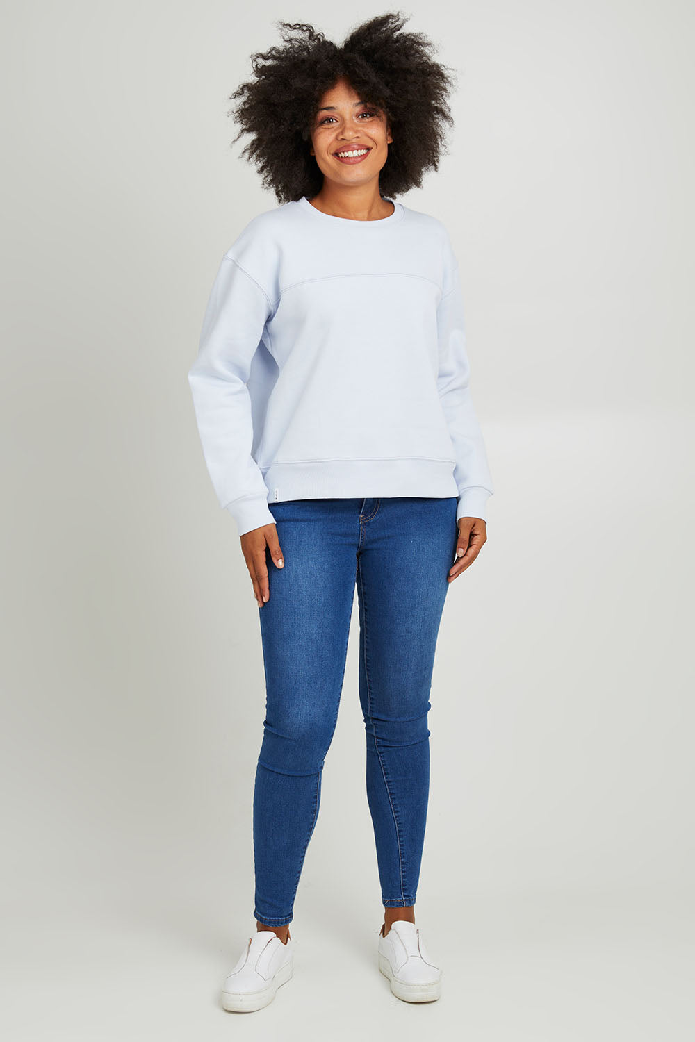 Model Olivia wearing size 10 of the Fundamental Shelly Fleece Crew in colour Lightblue (Blue), from the front, showing the whole outfit
