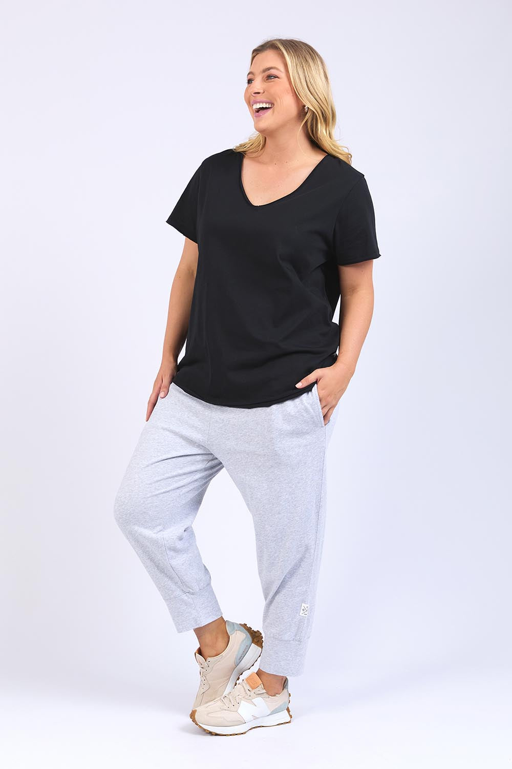 A model wearing the Fundamental Pima Cotton Vee Tee in colour Black (Black), from the front, showing the whole outfit