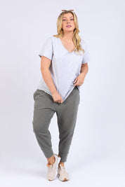 A model wearing the Fundamental Pima Cotton Vee Tee in colour Greymarle (Grey), from the front, showing the whole outfit