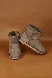 A model wearing the Platinum Stinger Mini Ugg Boots in colour Mushroom, from the front, showing the whole outfit