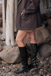 A model wearing the Blanche Leather Knee Boot in colour Black (Black), from the front, showing the whole outfit