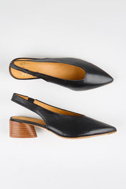 Model Genericm wearing size sample of the Hatti Heel - Black in colour Black, from an angle