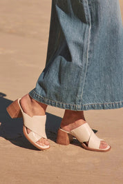 A model wearing the Iso Leather Heel in colour Bone, from the front, showing the whole outfit