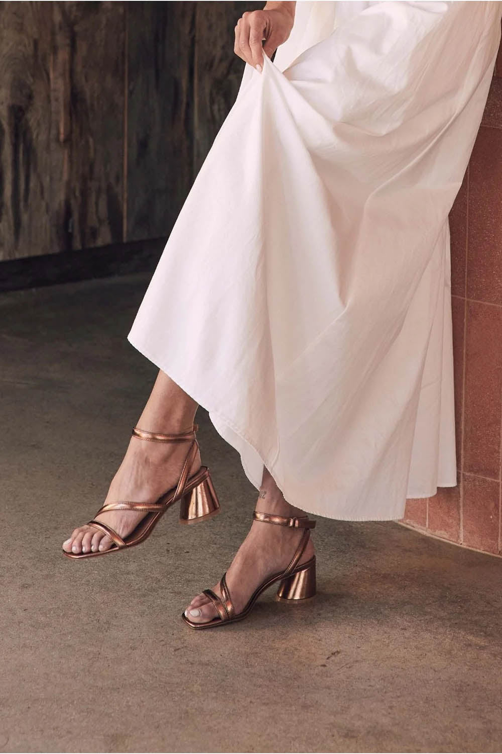 A model wearing the Petricia Leather Heel in colour Copper (Metallics), from the front, showing the whole outfit