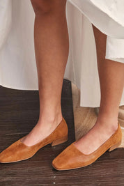 A model wearing the Solana Leather Flat in colour Brandy, from the front, showing the whole outfit