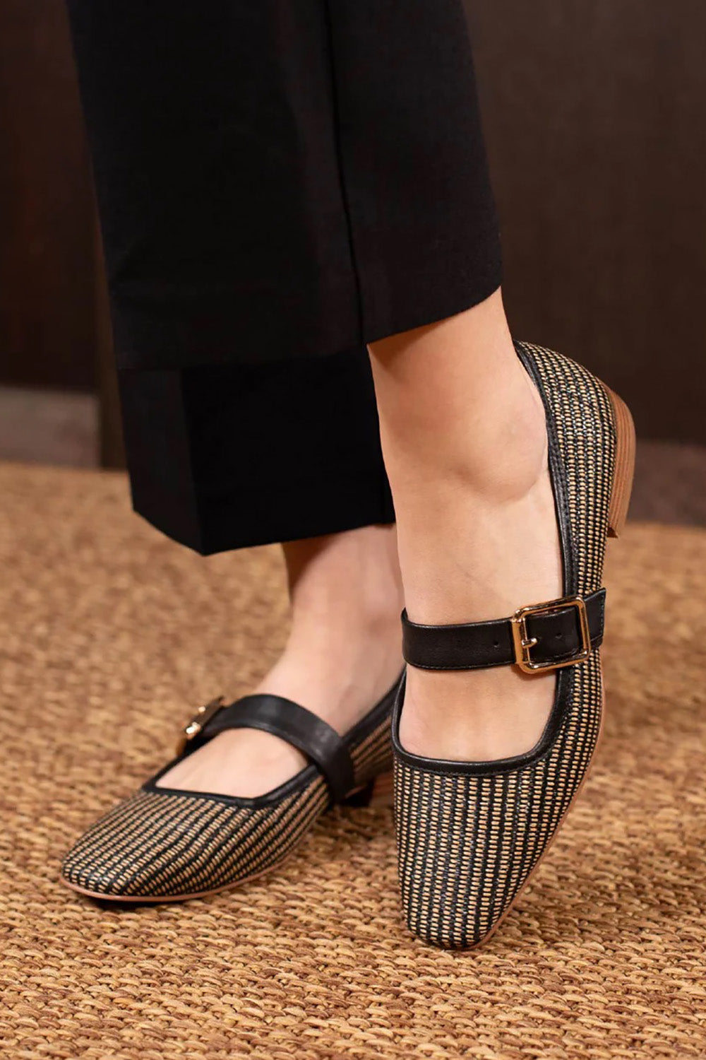 A model wearing the Sophy Leather Flat in colour Blackgrass (Black), from the front, showing the whole outfit