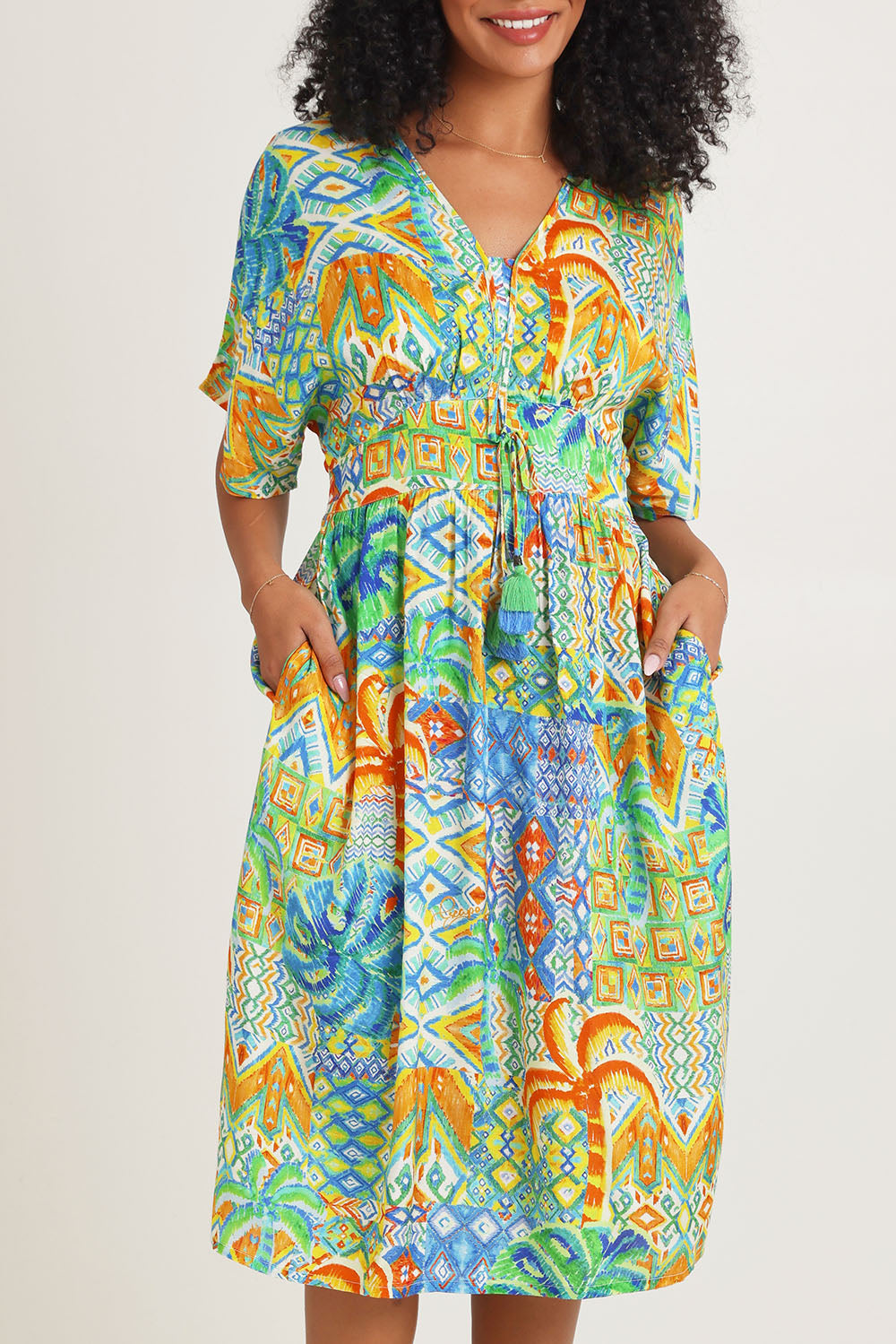Model Ziara wearing size 10 of the Fiorella Waist Dress in colour Print, from the front, cropped image
